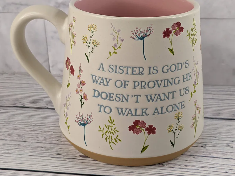 A religious mug for your sister with an inspirational saying and a flower design.
