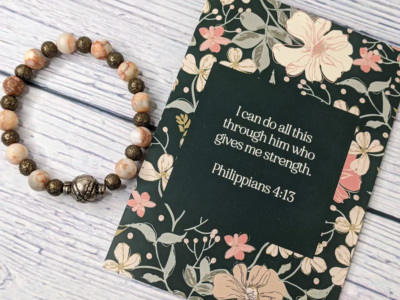 A Bible verse card with a beaded bracelet that has stone and metal beads. Philippians 4:13