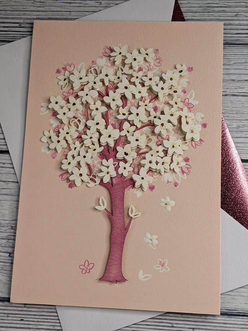 A pink Hallmark Signature greeting card that is blank inside with a dimensional image of a flowering tree on the cover.