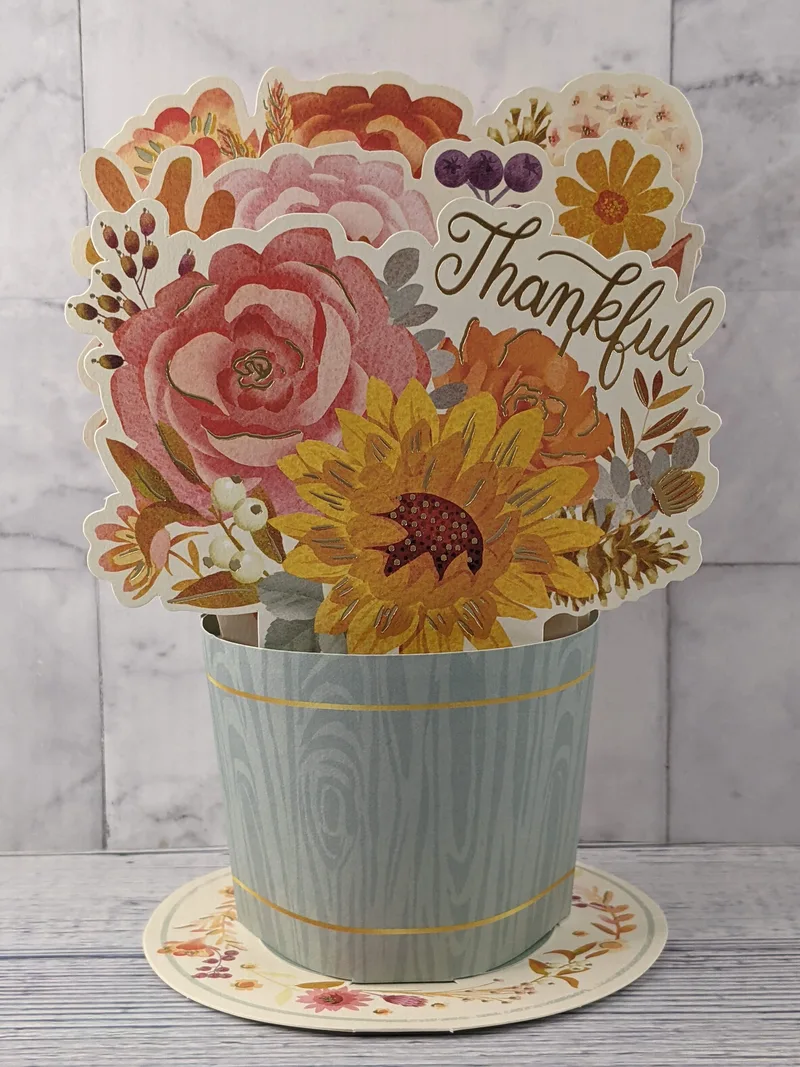 A pop-up paper flower bouquet greeting card by Hallmark Paper Wonder with a "thankful" message.