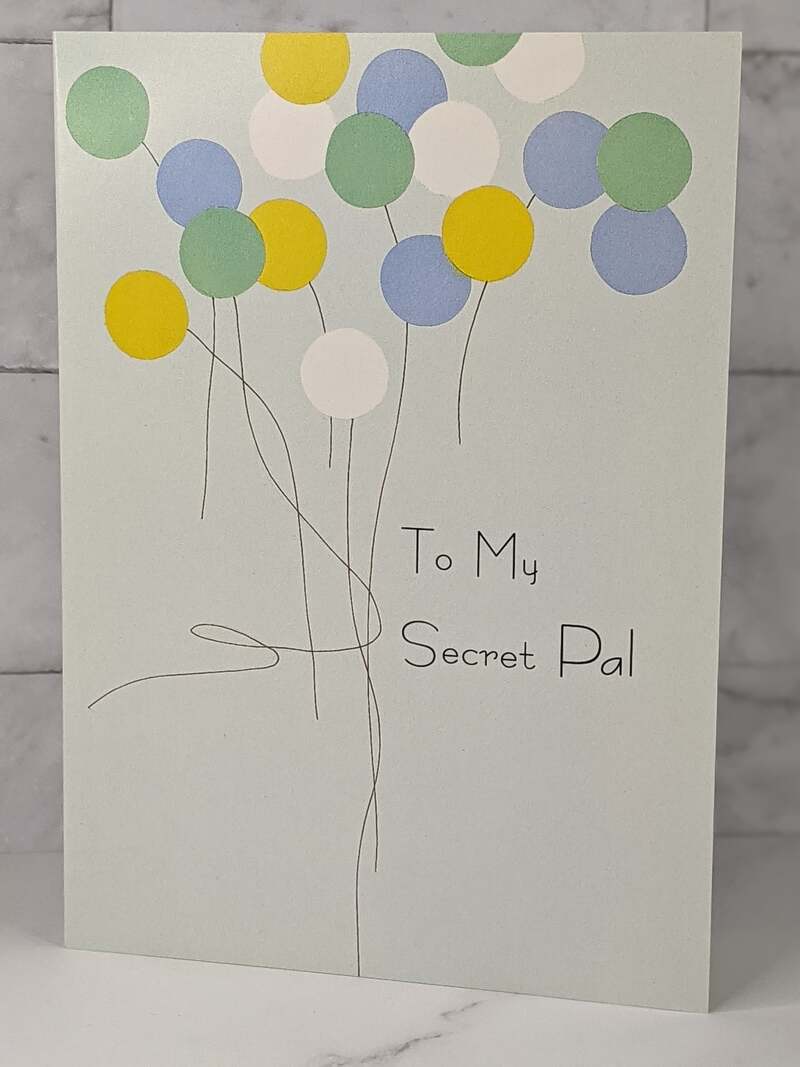 A religious birthday greeting card for a Secret Pal with a blue cover and a design of yellow, green and blue balloons.