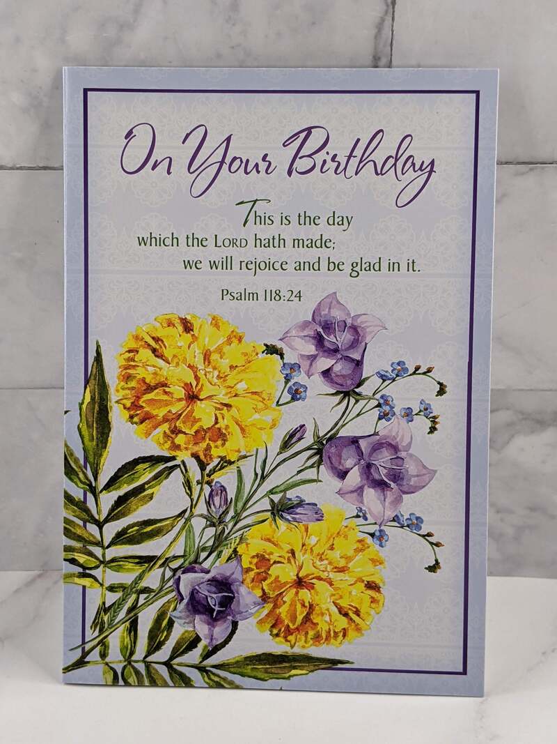 A Secret Sister birthday card with a design of yellow flowers on the cover and a religious message with a Bible verse.