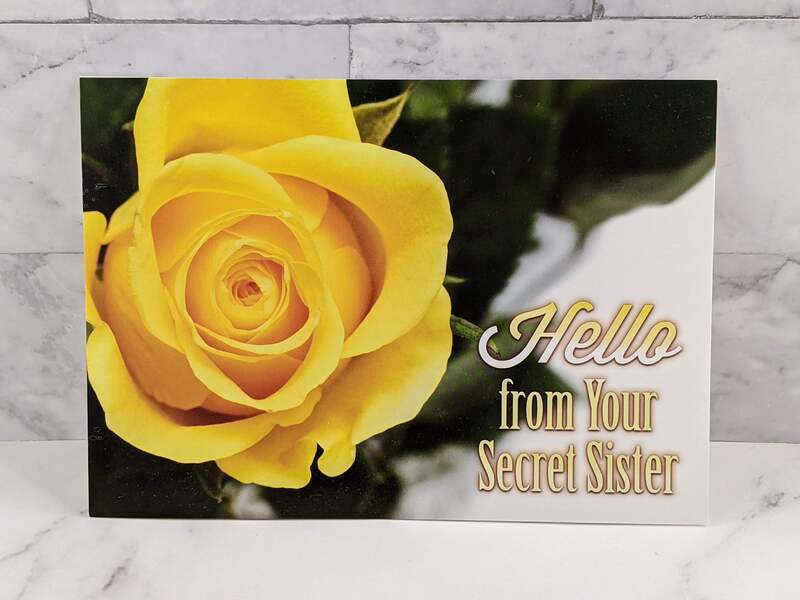 A Christian greeting card for with a yellow flower on the cover and text that says "Hello from Your Secret Sister"