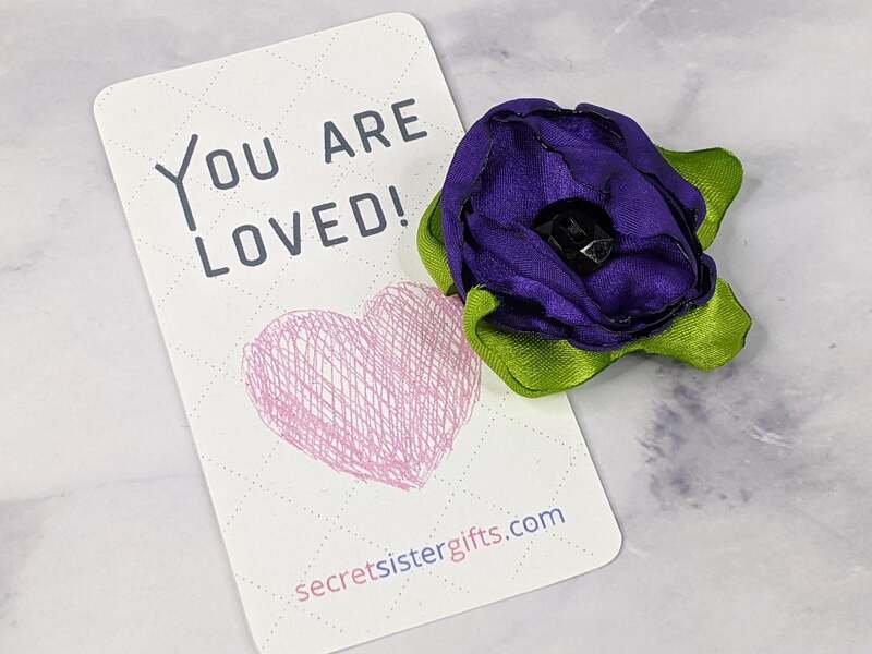 A beautiful handmade purple fabric flower magnet with a message tag: You Are Loved!