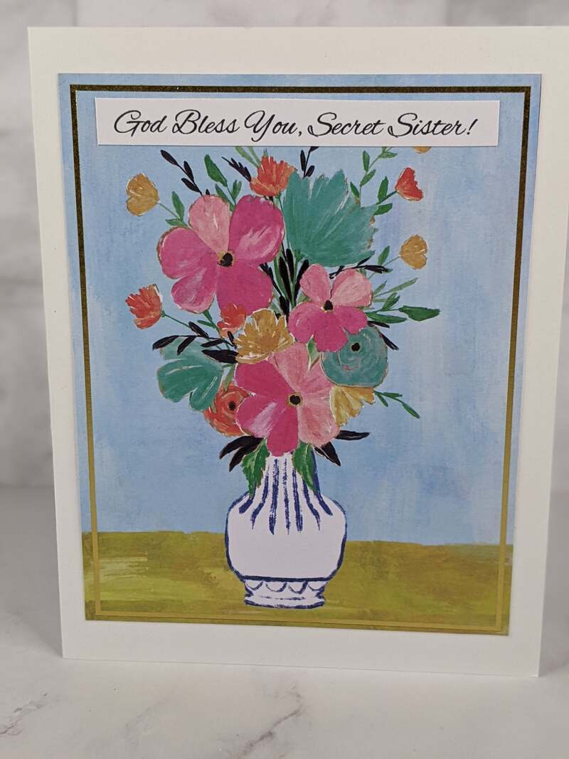 A pretty greeting card for your secret sister with a design on the front cover of a vase of flowers.